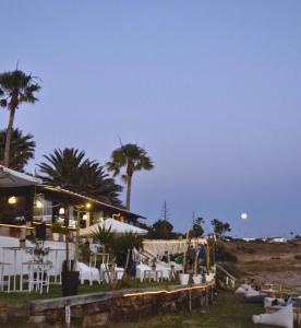 a restaurant with palm trees and a beach at night at Hostal Rios in Bolonia
