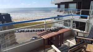 d'un balcon avec une table et une vue sur la plage. dans l'établissement Sterflat 199, à Egmond aan Zee