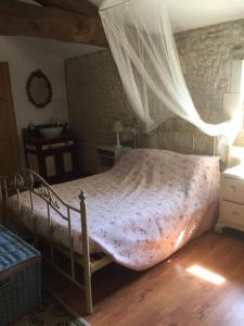a bedroom with a bed with a mosquito net at L'Oree du Bois in Cherbonnières +7 photos