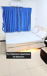 a bed in a room with a blue curtain at River View Bangkok in Bangkok