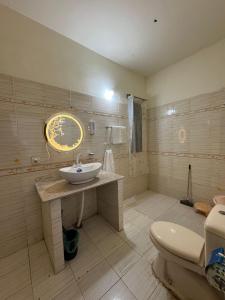 une salle de bain avec un lavabo et des toilettes dans l'établissement Rosewood Cottage, à Karachi