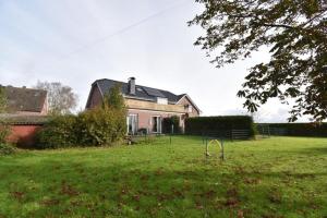 a large house with a yard with a swing at Ferienwohnung Labradoodle in Dornum