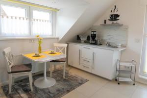 a kitchen with a table and a small table and chairs at Apartment Wallberg "Nest" in Detmold