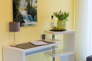 a table with a bottle of wine and a vase of flowers at Apartment Wallberg "Nest" in Detmold