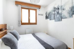 a bedroom with a bed and some pictures on the wall at Appartement pour 6, 700m des pistes de ski in La Joue du Loup