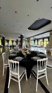 a dining room with a table and white chairs at Elazığ Mavigöl Otel in Sivrice