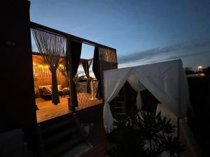 a tent on the deck of a house at night at Glamour tinyhouse in Muret