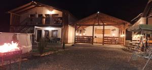 a building with a fire in the yard at night at Cabana Oprișor in Ocna Sibiului