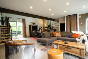 un salon avec un canapé et une table dans l'établissement Villa Ty Amor - avec grand jardin et jacuzzi pour 9, à Kerdamiet