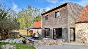 une extension d'une maison en briques avec un patio dans l'établissement Villa Ty Amor - avec grand jardin et jacuzzi pour 9, à Kerdamiet