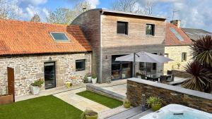 Cette maison dispose d'une terrasse avec un parasol. dans l'établissement Villa Ty Amor - avec grand jardin et jacuzzi pour 9, à Kerdamiet 13 autres photos