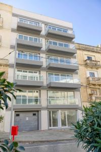 a tall building with windows on the side of it at Beautiful Modern Central 2BR Apt in Taʼ Xbiex