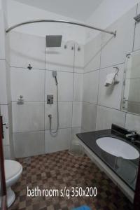 a bathroom with a shower and a sink and a toilet at Hotel Chithrapuri in Parli +15 photos