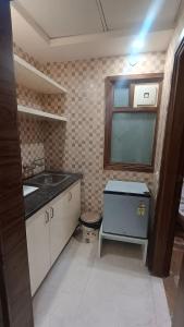 Una pequeña cocina con fregadero y ventana. en HD Luxury hotel, en Nueva Delhi