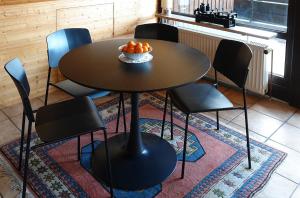 einen Tisch mit Stühlen und eine Schüssel Orangen darauf in der Unterkunft Ferienwohnungen Vesteblick in Dörfles