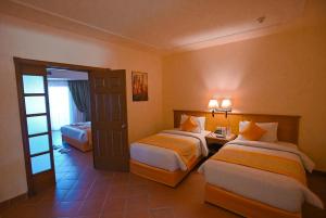 a hotel room with two beds and a door at Charmillion Gardens Aquapark in Sharm El Sheikh +17 photos