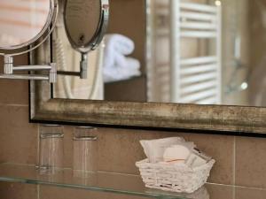 een spiegel en een mand met toiletartikelen in de badkamer bij Hotel Paradiesquelle 4 in Puchberg am Schneeberg +57 foto's
