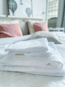 a stack of white towels sitting on a bed at The Doors City Park House in Ghent +52 photos