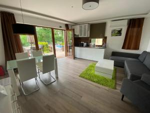 una sala de estar con una mesa y un sofá en Terrasun Apartments, en Balatonszárszó