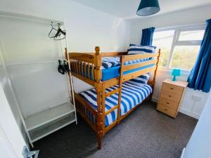 a bedroom with two bunk beds and a window at Freshwater Bay Holiday Cottages in Pembroke