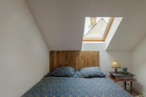 a bedroom with a bed and a small window at Le Quincy - Maison à 10km de Disneyland in Quincy-Voisins