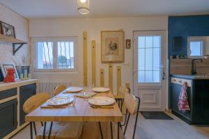 a dining room with a wooden table and chairs at Le Quincy - Maison à 10km de Disneyland in Quincy-Voisins
