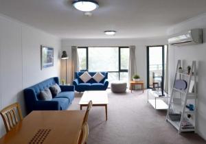キャンベラにあるSunny Braddon Apt near Civic - Hosted by Canstayの青いソファとテーブルのあるリビングルーム