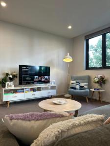 a living room with a large flat screen tv at Cosy getaway in the Heart of Braddon - Hosted by Canstay in Canberra
