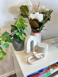 a shelf with a vase of white flowers and a heart holder at Cosy getaway in the Heart of Braddon - Hosted by Canstay in Canberra