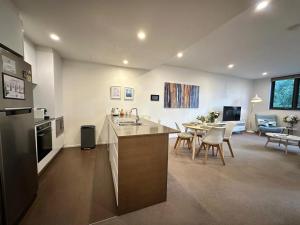 a kitchen and living room with a table and chairs at Cosy getaway in the Heart of Braddon - Hosted by Canstay in Canberra