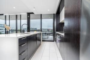 a kitchen with stainless steel appliances and large windows at Kingston Foreshore Paradise - 2BR - Hosted by Canstay in Kingston 