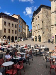 a group of people sitting at tables in a courtyard at Paloma in Figeac