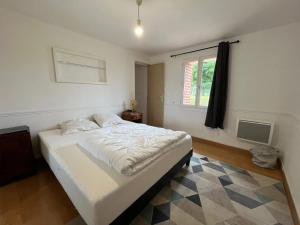 ein Schlafzimmer mit einem großen weißen Bett mit einem Fenster in der Unterkunft Maison charmante à Bec-de-Mortagne avec jardin clôturé in Bec-de-Mortagne