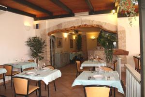 a restaurant with tables and chairs in a room at Hotel Geranio Rosso in Stintino