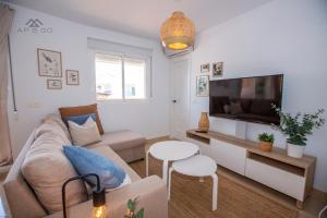 Una sala de estar con un sofá y un televisor de pantalla plana. en Fuerte Penthouse Great Location, en La Herradura