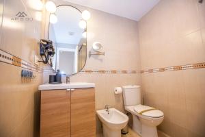 Un baño con inodoro, lavabo y espejo. en Fuerte Penthouse Great Location, en La Herradura 10 fotos más