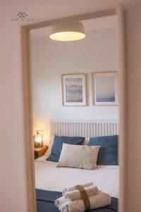 Un dormitorio con una cama con almohadas azules y un espejo. en Fuerte Penthouse Great Location, en La Herradura