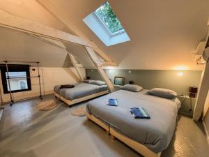 a attic bedroom with two beds and a skylight at Charmante maison de ville avec vue sur le donjon avec wifi et jardin in Gouffern en Auge