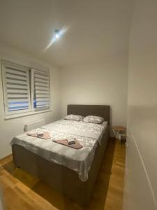a bedroom with a bed and a window at Astra apartman BL in Banja Luka