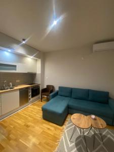 a living room with a blue couch and a table at Astra apartman BL in Banja Luka