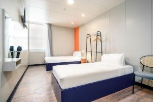 a small room with two beds and a chair at Herculano Stays Porto - Digital Access in Porto