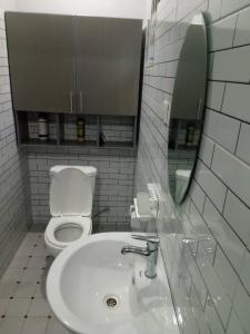 ein Badezimmer mit Toilette, Waschbecken und Spiegel in der Unterkunft Entebbe Katabi Regency Estate in Entebbe + 13 Fotos