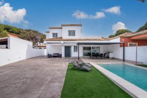 a house with a swimming pool and a yard at Villa Empul La Caracola in Chiclana de la Frontera