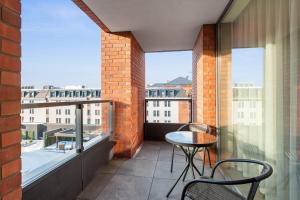 een balkon met een tafel en stoelen op een balkon bij Scala City Center Apartments with Parking by Lion Apartments in Gdańsk