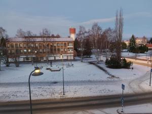 a building with a snow covered yard in front of a building at Hostel Kulma in Lieksa