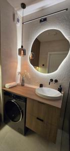 un baño con lavabo y espejo en Vilda Moderne, en Poznan 14 fotos más