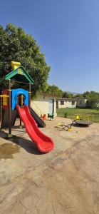 a playground with a red slide in a park at Teak Resort Karjat in Karjat