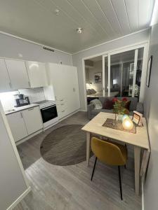 a kitchen and living room with a table and a couch at Central City Apartment in Svolvær