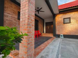 Batang BerjuntaiBRIK 'N BATA的庭院里砖砌的房子,配有红色椅子