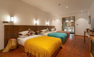 Postel nebo postele na pokoji v ubytování Lijiang Snow Mountain Bengu Hotel-Shuhe Ancient Town Branch 丽江雪山奔鼓酒店-束河古镇店